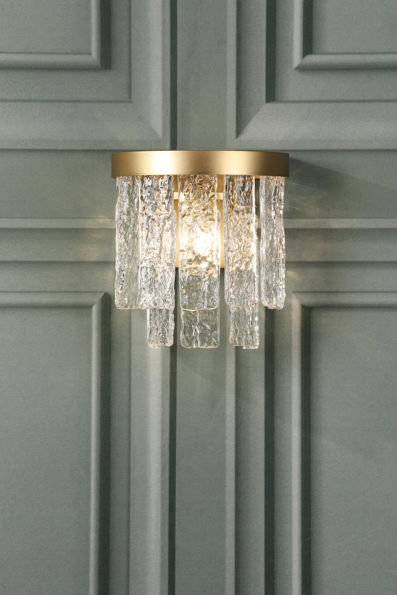 A beatiful decorative wall light with downward crystals and an antique brass finish.