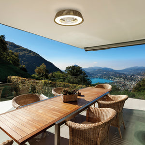 Modern terrace with wicker chairs, wooden table, and ceiling light-fan overlooking lake and mountain view.